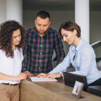 People reviewing documents at counter